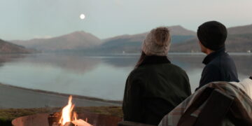 Two people looking across a Scottish lake