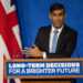 Rishi Sunak standing delivering a speech at the Downing Street press room.