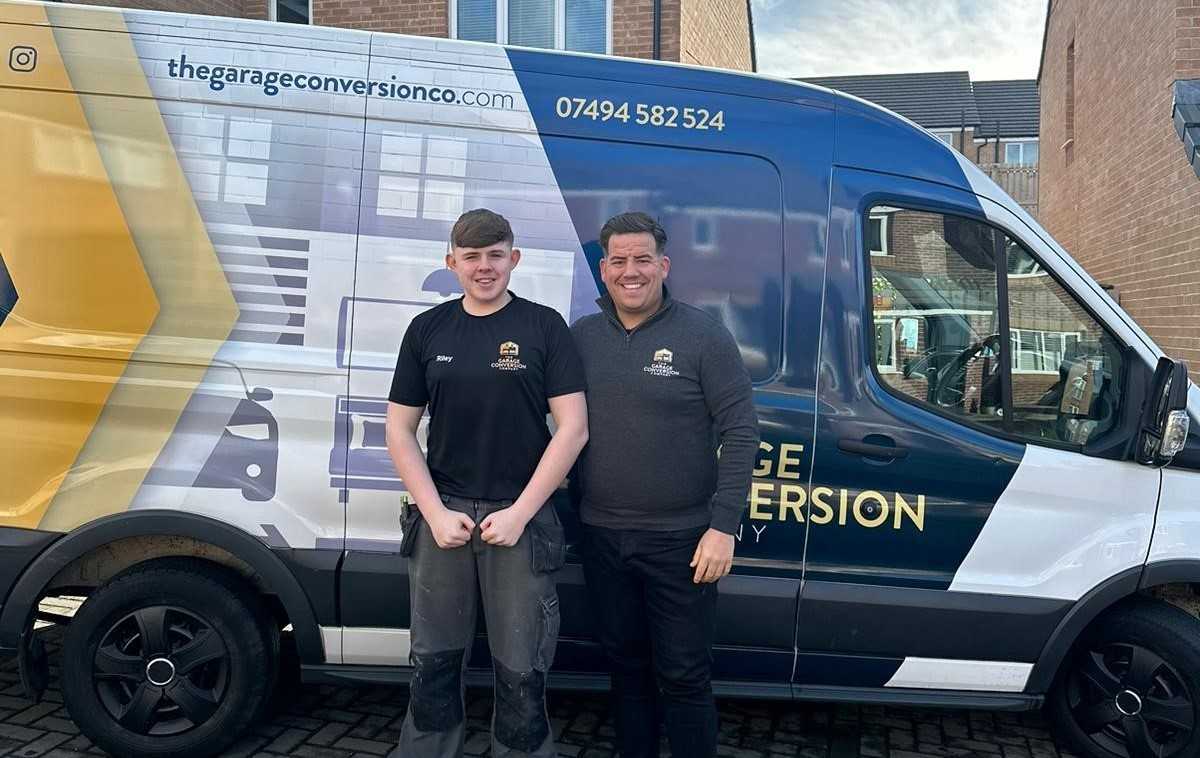 Riley Fraser and Derek Wilson standing infront of the company van.