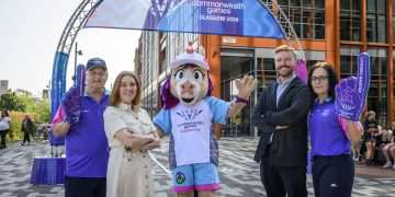 An image of Louisa Mahon, Chief Marketing Officer and Chris Ansell, Director of Live Programmes and Engagement with volunteers and Finnie down by the Clyde where the mile begins.