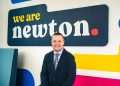 An image of Vincent Goldie standing in front of the Newton Property Management sign.