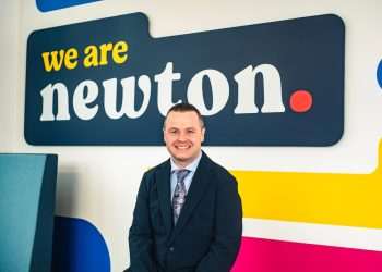 An image of Vincent Goldie standing in front of the Newton Property Management sign.