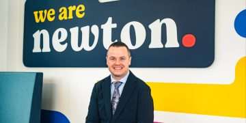 An image of Vincent Goldie standing in front of the Newton Property Management sign.